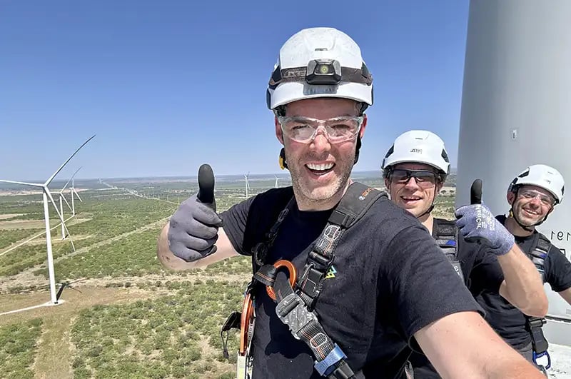 3 LAIIER employees on top of a wind turbine