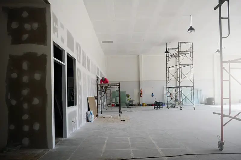 Person drywalling an office