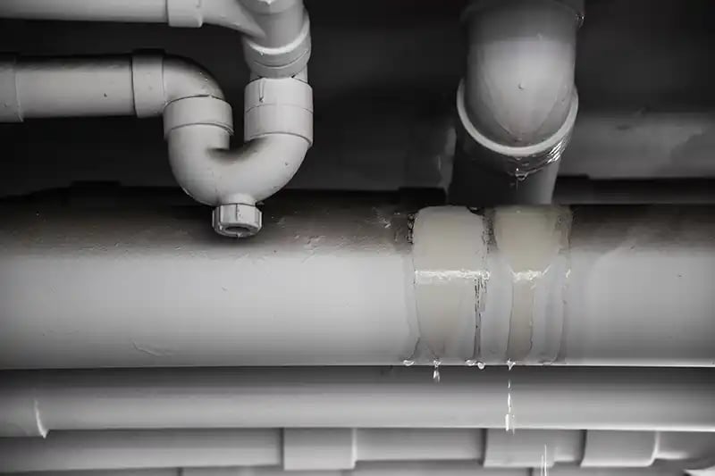 Water leaking from white PVC pipes