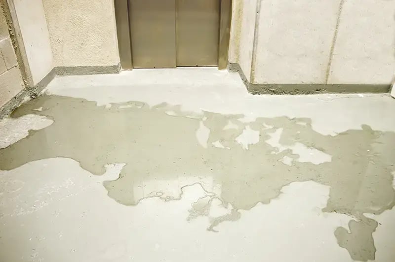 Water pooled on a concrete floor in a basement