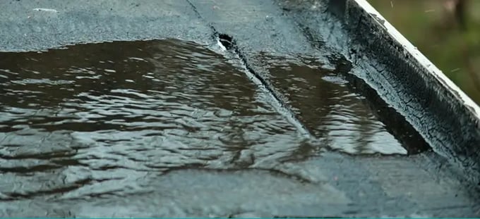 Flat roof with visible damage and water pooling