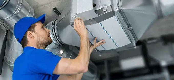 HVAC technician inspecting ventilation system