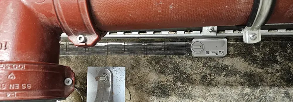 LAIIER water leak sensor underneath a large red pipe
